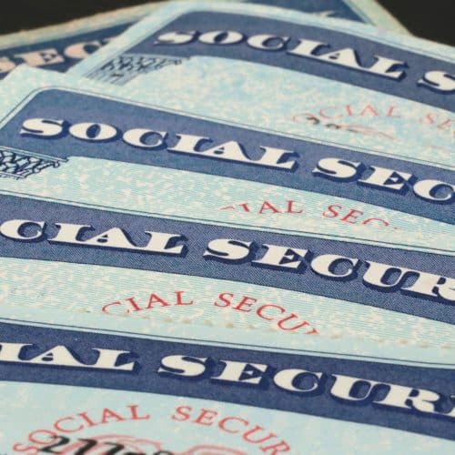 Multiple social security cards are positioned in a row.