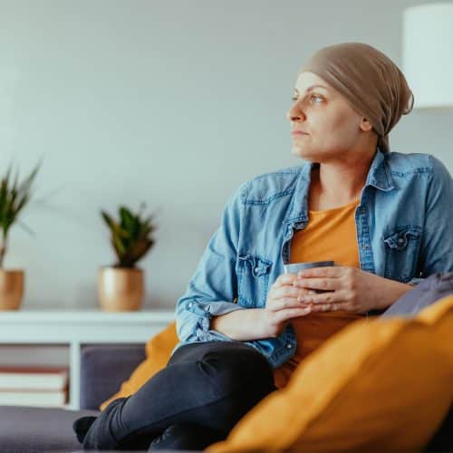 A woman sits in her home in Los Angeles wondering if her cancer symptoms qualify her for Social Security.