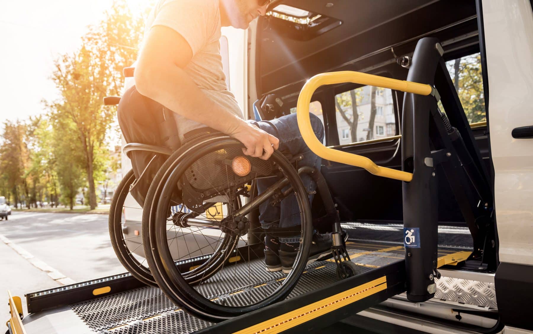 A man in a wheelchair getting on a bus in Los Angeles.